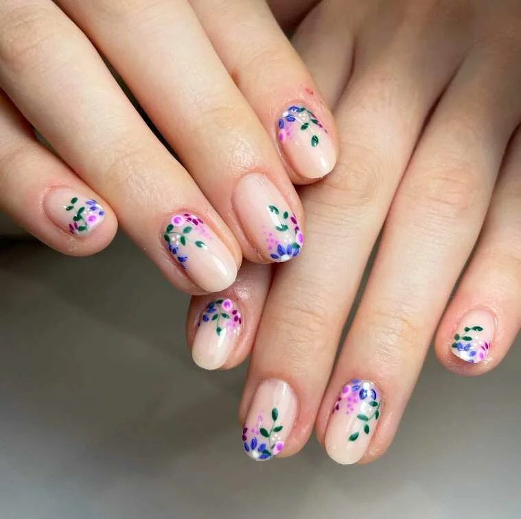 Red daisy pink French tip floral nails - beautiful hand showcasing red daisy base with pink French tips, featuring white flower petals and green leaves on almond-shaped nails